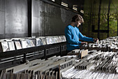 A young man searching through records in a record store