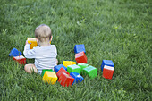 Baby in the garden with building blocks