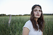 Profile of girl with hair band standing in field looking to the side