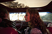 A rockabilly couple in the front seat of a vintage car