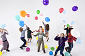 A group of kids playing with balloons