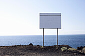 A blank billboard next to the sea