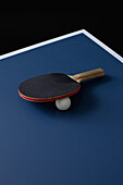 A table tennis bat and ball on a table