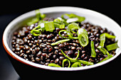 Close-up of garnished black lentils in bowl