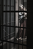 Madonna and child statue behind barred window