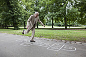 Senior man playing hopscotch in the park