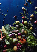High angle view of fresh vegetables and fruits scattered on blue table