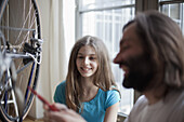 Father and daughter repairing bicycle at home