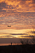 Airplane against cloudy sky during sunset