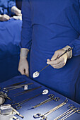 Midsection of a man holding a surgical instrument