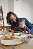 Happy father with baby girl playing at table