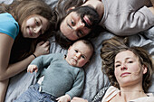 High angle portrait of family relaxing on bed