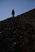 Rear view of a woman hiking up Lonquimay Volcano, Patagonia, Chile