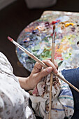 Female artist holding paintbrush, close-up