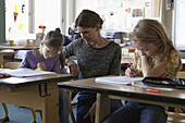 Teacher teaching to girls in classroom