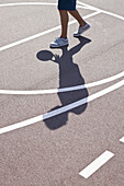 Man playing basketball, low section