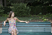 Young woman sitting on park bench