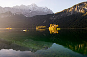 Kayaker paddling on lake Eibsee below Zugspitze, Grainau, Bavaria, Germany