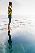 Frau steht auf einem Poolrand und blickt über das Meer, Hotelanlage Wawa-Wewe II, Amed, Bali, Indonesien
