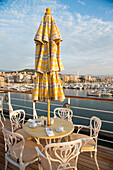 Sonnenschirm, Tisch und Stühle vom Lido Café an Deck von Kreuzfahrtschiff MS Deutschland (Reederei Peter Deilmann), Palma, Mallorca, Balearen, Spanien, Europa