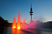 Illuminated water fountain in the park lake, television tower in the background, Planten un Blomen, Hamburg, Germany