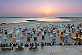 Menschen auf der Strandpromenade betrachten den Sonnenuntergang, Insel Borkum, Ostfriesland, Niedersachsen, Deutschland