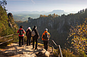 Hikers at a lookout point, view over Wehlgrund to Bastei rocks, Lilienstein in the background, National Park Saxon Switzerland, Elbe Sandstone Mountains, Saxony, Germany