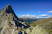 Frau steht vor Wegweiser in der Forcella Valon, Trans-Lagorai, Lagorai-Höhenweg, Lagorai, Dolomiten, UNESCO Welterbe Dolomiten, Trentino, Italien