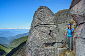 Frau wandert auf versichertem Steig zwischen Felsblöcken hindurch, Trans-Lagorai, Lagorai-Höhenweg, Lagorai, Dolomiten, UNESCO Welterbe Dolomiten, Trentino, Italien