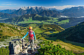 Woman ascending fixed rope route, Loferer Steinberge range in background, fixed rope route Henne, Henne, Kitzbuehel range, Tyrol, Austria
