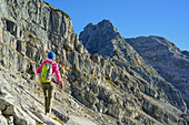 Woman hiking towards Rothorn, Nurracher Hoehenweg, Ulrichshorn, Loferer Steinberge range, Tyrol, Austria