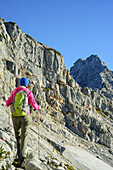 Woman hiking towards Rothorn, Nurracher Hoehenweg, Ulrichshorn, Loferer Steinberge range, Tyrol, Austria