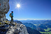 Frau wandert auf Felsband mit Blick auf Hohe Tauern, Nurracher Höhenweg, Loferer Steinberge, Tirol, Österreich