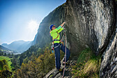 Frau klettert über Gneisfelsen, Torbeccio, Maggiatal, Tessin, Schweiz