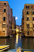 moon between houses on canal, evening, washing lines, boats, decay,  Venice Italy
