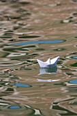 Papierschiff, weiss, gefaltetes Papierboot auf Wellen im Canal Grande, Venedig, Italien