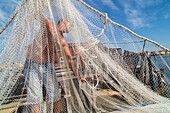Fishermen with bilanciono nets on a traditional casone, shelter on stilts, Pellestrina, Island, lagoon, Venice, Italy