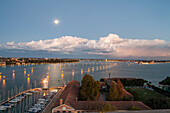 evening view, clouds, moon, from campanile of church San Giorgio Maggiore, island, Venice yacht club, Canale di San Marco, lit harbour entrance, Venice, Italy