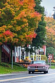Vintage car driving through the picturesque town of Weston in the Indian Summer, Vermont, USA