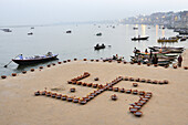 India, Uttar Pradesh, Varanasi, Swastika shaped earthen lamps set for Dev Deepawali festival.