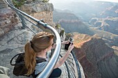 young woman documenting the Grand Canyon.