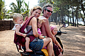 The Reynolds family on holiday in Goa transport the family Indian style 5-up on a moped, Turtle Beach, Goa, India.