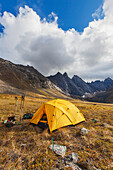 Campsite on the autumn tundra with a view of East and West Maiden and Camel peaks in the distance, Arrigetch Peaks, Gates of the Arctic National Park, Alaska.