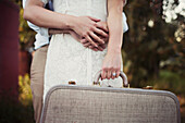 'A couple holding a vintage suitcase; Edmonton, Alberta, Canada'