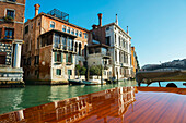 'Buildings along the shoreline of the Grand Canal viewed from a boat; Venice, Veneto, Italy'