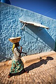 'A young girl walking through the colourful streets of the old city of Harar in Eastern Ethiopia; Harar, Ethiopia'