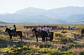 'Horseback riding in a rural area with mountains in the distance; Malargue, Argentina'