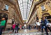 'Pedestrians walking under a domed glass ceiling between buildings; Milano, Italy'