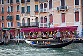 'A gondolier in a gondola outside Hotel Marconi; Venice, Italy'
