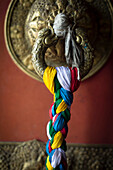 A colorful braided cloth adorns the door of the Swayambu Temple complex in Kathmandu, Nepal